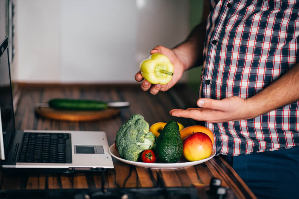 Overweight man blogger recording video in his kitchen
