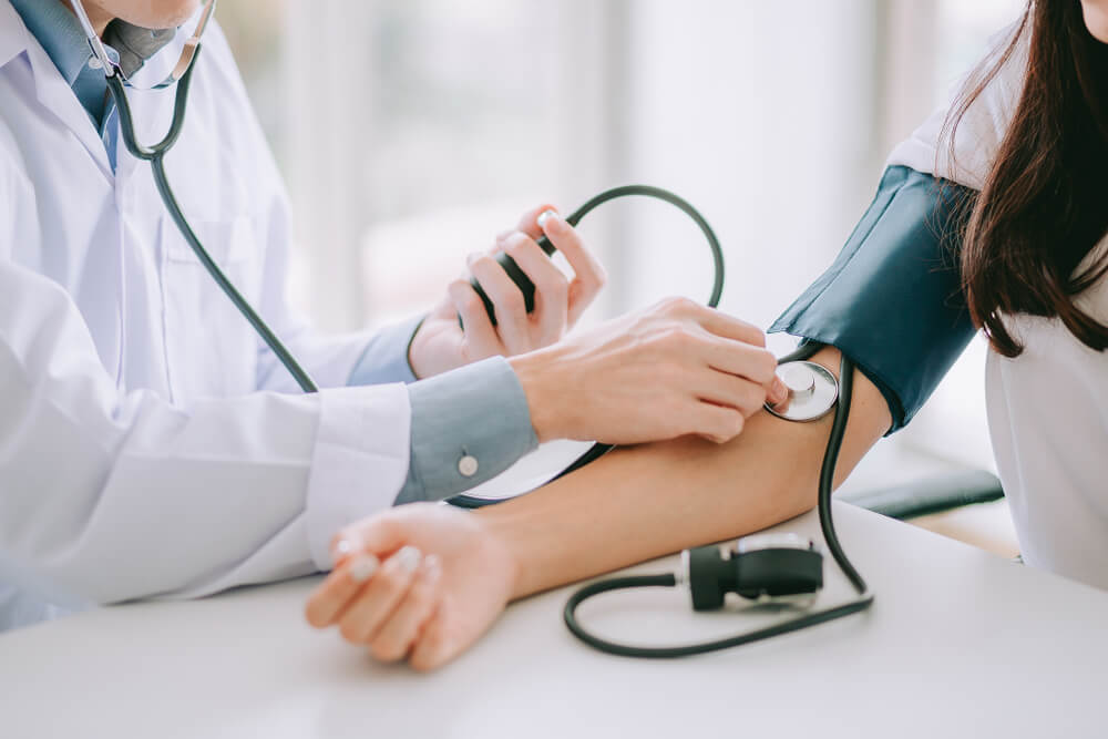 Doctor using sphygmomanometer with stethoscope
