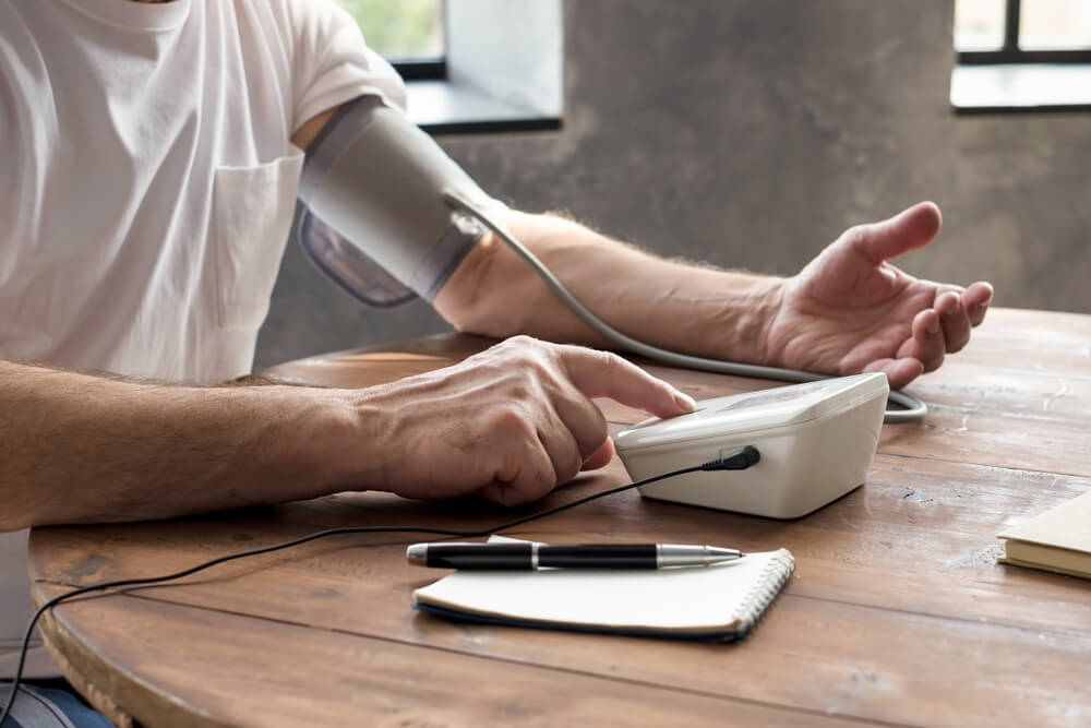 Senior man using a home blood pressure machine