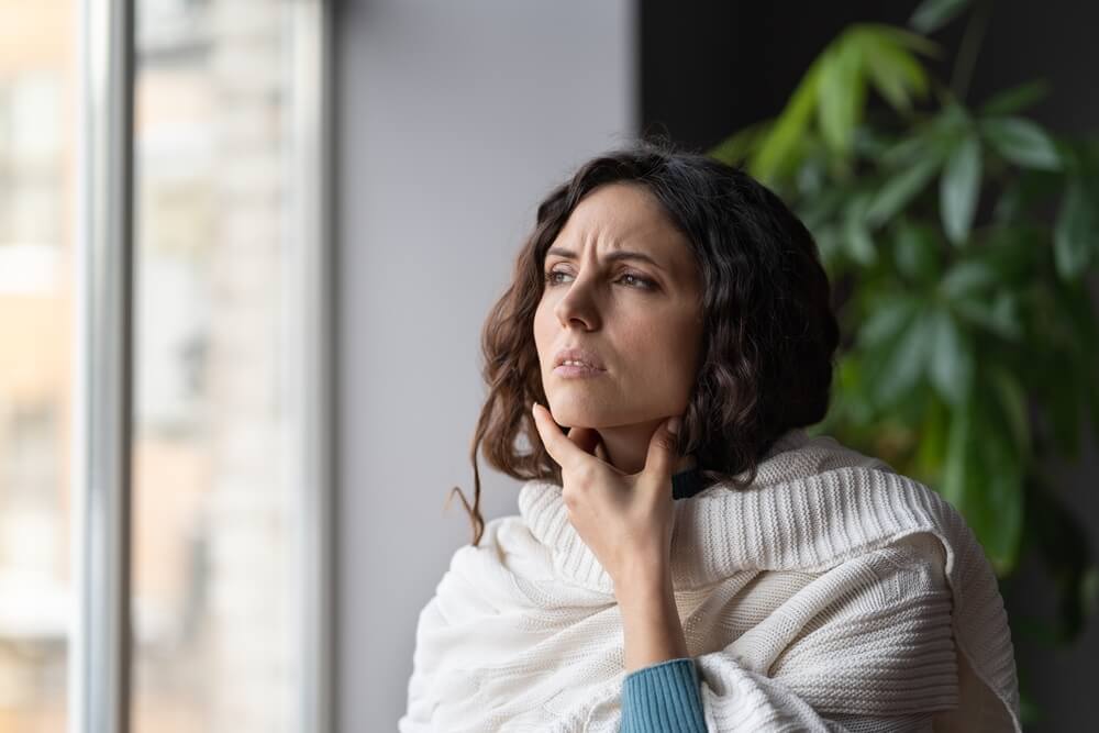 woman touching painful swollen neck glands, suffering from throat infection