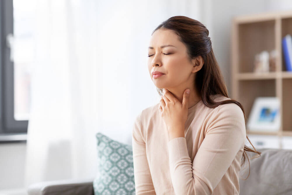 Woman with sore throat at home
