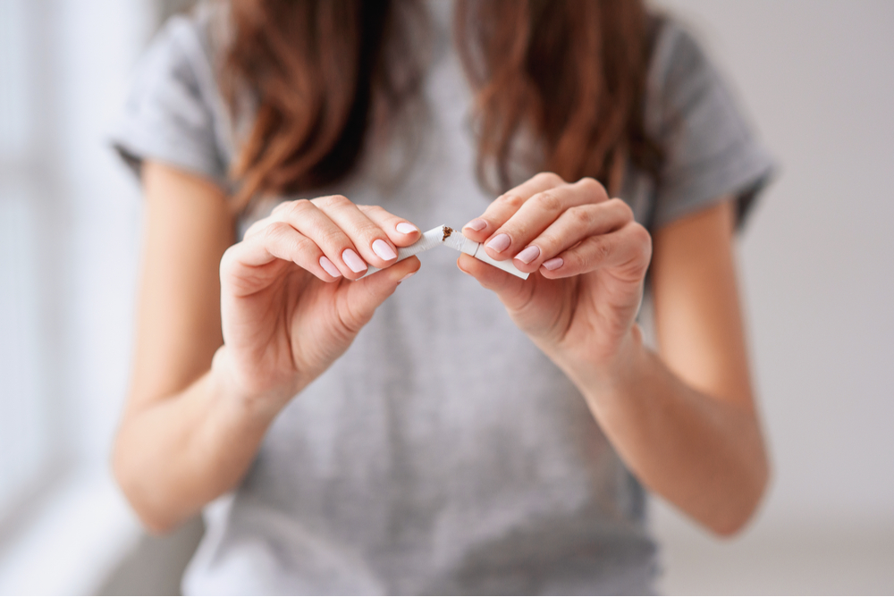 beautiful girl holding broken cigarette in hands