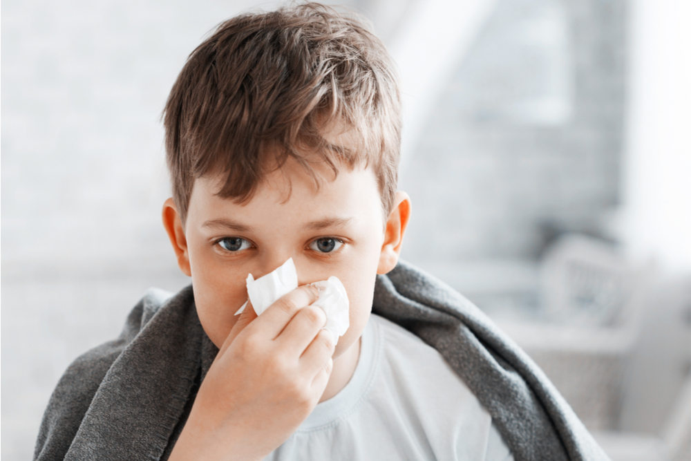 Boy get cold and blow her nose at home.