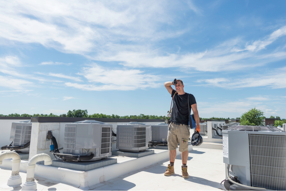 Hot day for an HVAC technician on a roof top during the summer