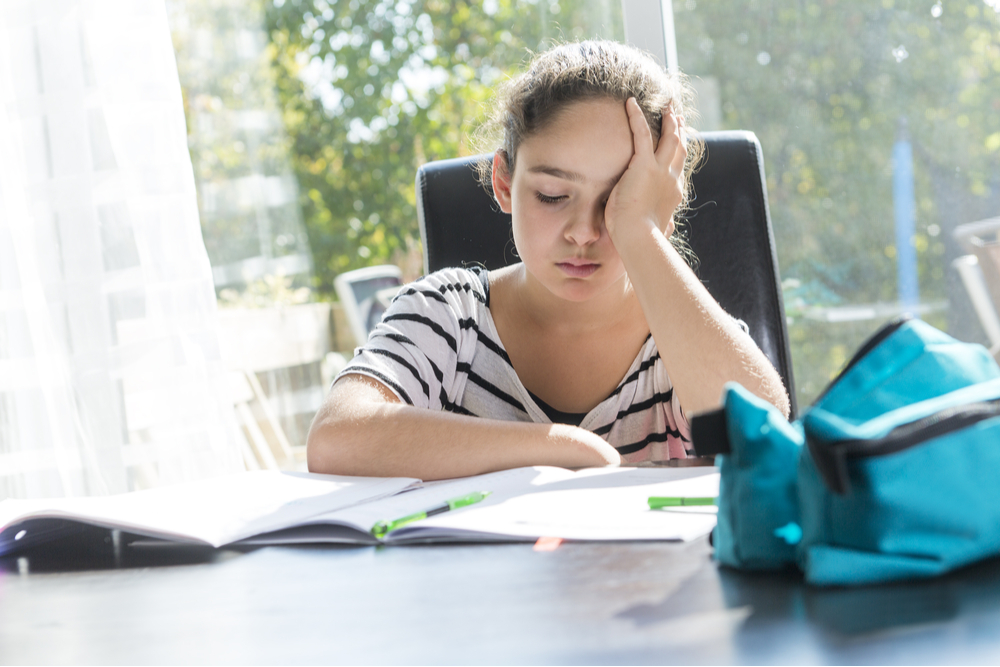 A schoolgirl studying with books