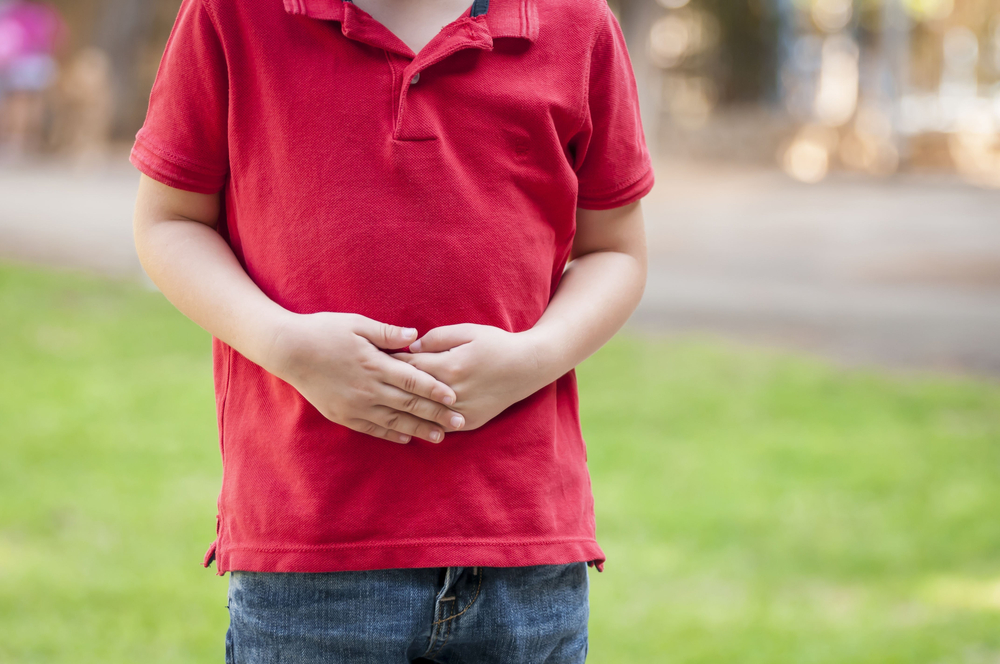boy holding his hands on his belly.