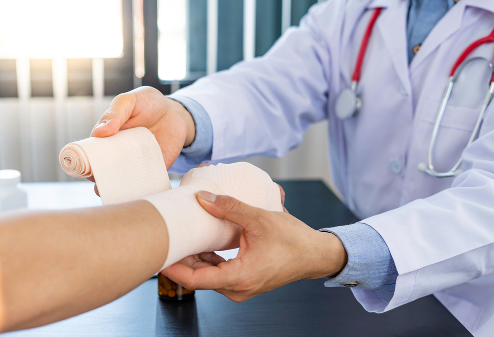 Doctor wrapping patients arm while explaining Urgent Care services